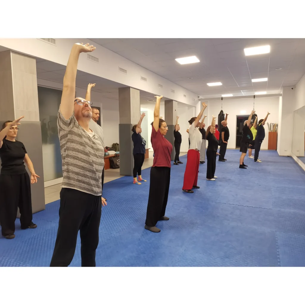 Allievi durante un movimento lento di apertura nello Shaolin Qigong
