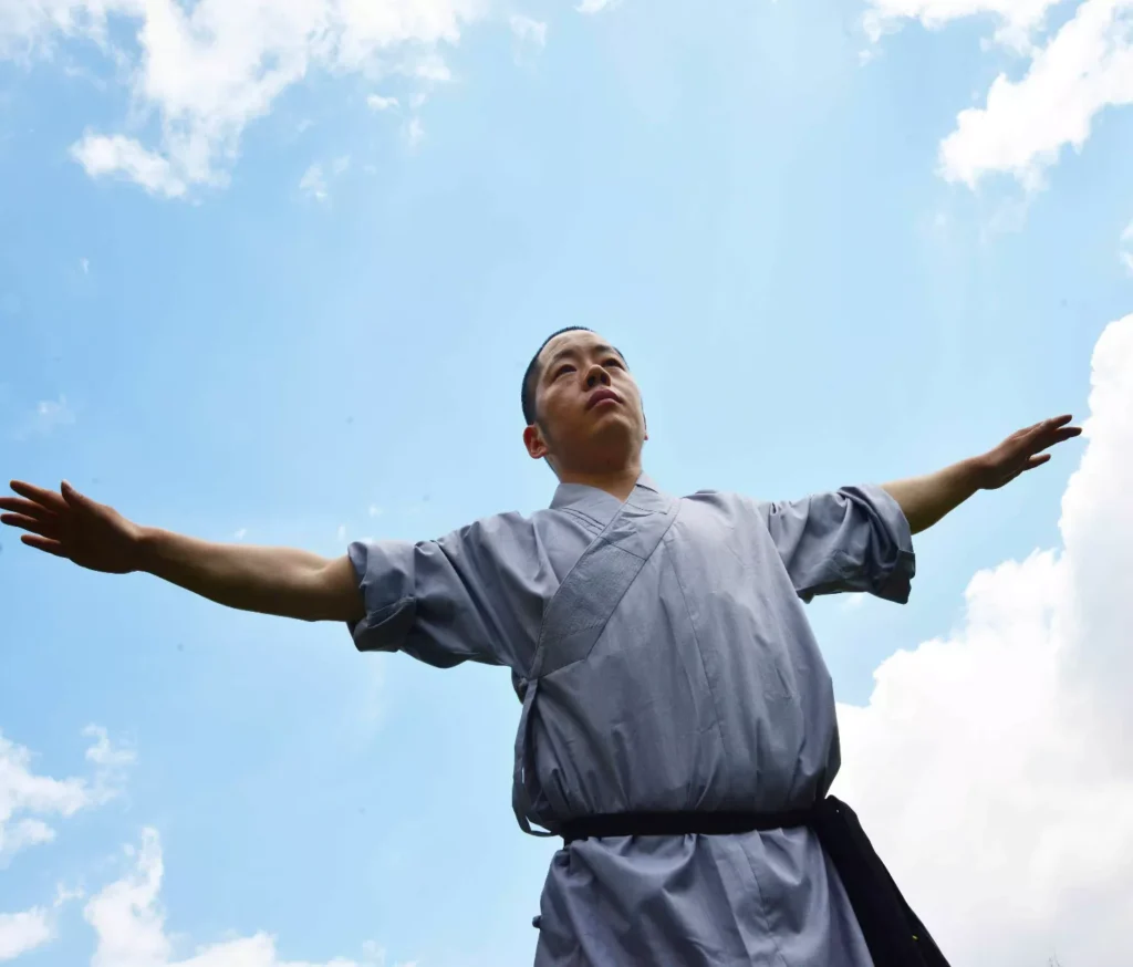 Maestro Shi Yan Hui con le braccia aperte durante una pratica di Shaolin Qigong